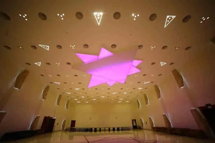 The vaulted interior of CK Conventions under coloured lighting